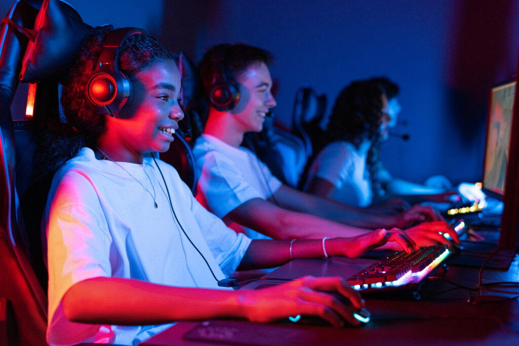 group-multiracial-teens-headsets-playing-video-games-video-game-club-with-blue-red-illumination-keyboard-mouse-with-illumination