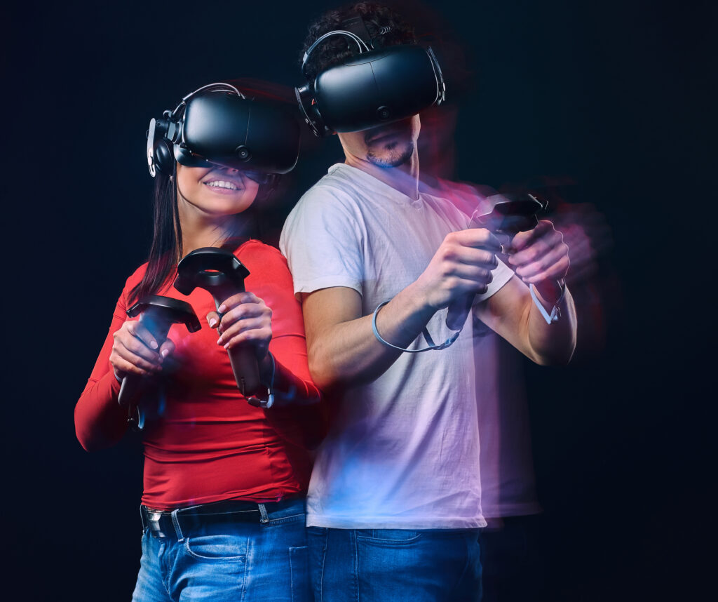 happy-friends-playing-video-games-wearing-virtual-reality-glasses-with-controllers-isolated-dark-background-photo-with-light-effect